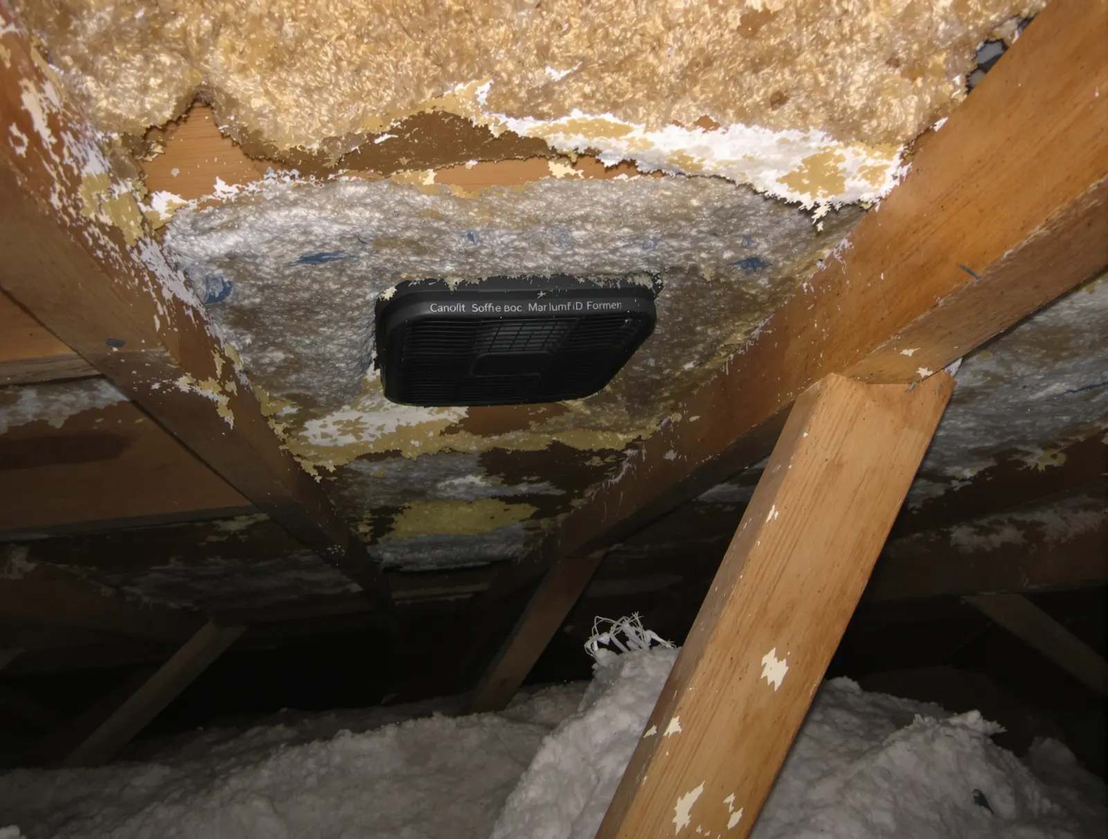 Soffit vent area blocked by insulation that has migrated over the vent opening at the eave